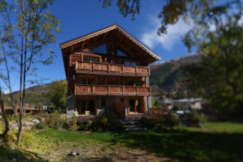 a large wooden house with a balcony on a hill at Les Alpages d'Auguste in Valloire