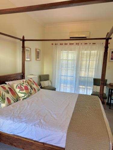 a bedroom with a large bed with white sheets and windows at York Wildflower Junior Suite in York
