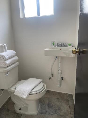 a bathroom with a white toilet and a sink at Hotel La Sexta in Tijuana