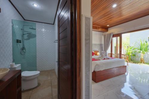a bathroom with a bed and a shower and a toilet at Lavanya Villa in Nusa Penida
