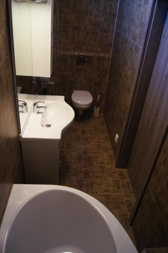a bathroom with a white toilet and a sink at Apartman Panorama in Štúrovo