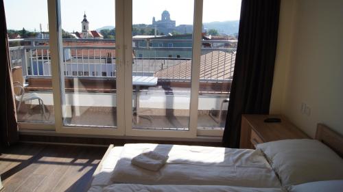 a bedroom with a bed and a large window at Apartman Panorama in Štúrovo