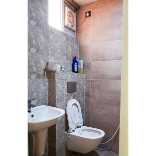 a bathroom with a toilet and a sink at Kimaya's Abode in Chandīgarh