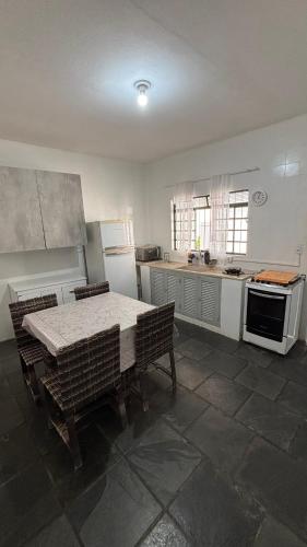 a kitchen with a table and chairs and appliances at Casa com 3 quartos in Itu
