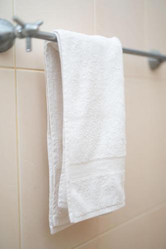 a white towel hanging on a towel rack in a bathroom at Abalone Stay in Bentota