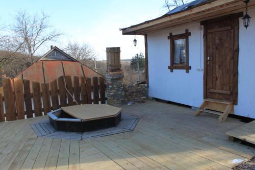 a wooden deck with a house and a wooden fence at Dykyi Khutir in Melʼniki