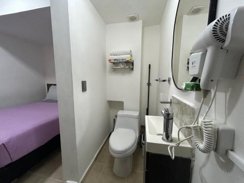 een kleine badkamer met toilet en wastafel bij Pequeño Alojamiento in Cancun