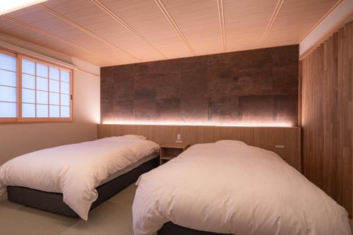 ein Schlafzimmer mit zwei Betten und einem Fenster in der Unterkunft tango resort ragura kitsu bettei in Kyōtango