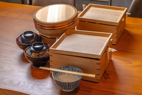 Zwei Holzkisten stehen auf einem Tisch, dazu Essstäbchen. in der Unterkunft tango resort ragura kitsu bettei in Kyōtango