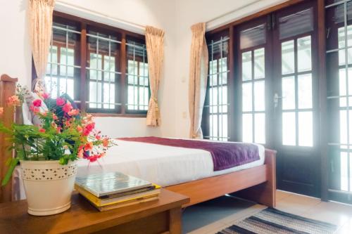 a bedroom with a bed and a table with flowers at Abalone Stay in Bentota