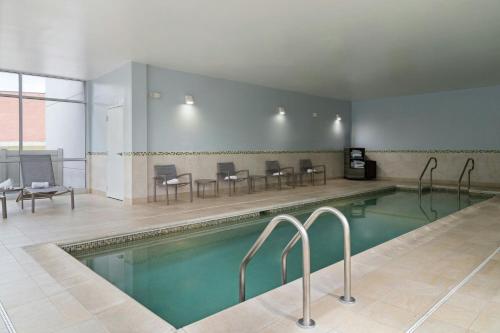 a swimming pool with chairs and tables in a building at SpringHill Suites by Marriott Voorhees Mt. Laurel/Cherry Hill in Voorhees