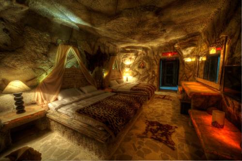 a bedroom with two beds in a rock cave at Caves Beach Resort Adults Only in Hurghada