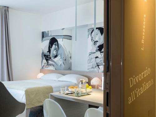 a hotel room with a bed and a table with drinks at Duomo Suites & Spa in Catania