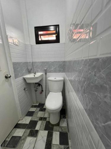 a bathroom with a toilet and a sink at Casa Ginhawa Ozamiz in Ozamis
