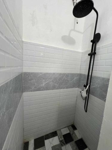 a bathroom with a shower with white and gray tiles at Casa Ginhawa Ozamiz in Ozamis