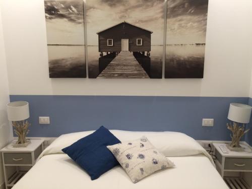 1 dormitorio con 1 cama y una pintura de un muelle en B&B Acqua di Sale, en Manfredonia