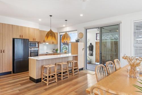 a kitchen and dining room with a table and chairs at Currumbin Beach House - 120m to the beach in Gold Coast