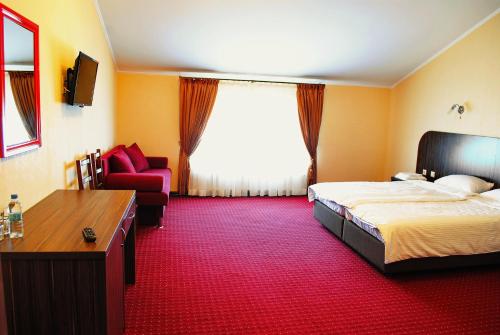 a hotel room with a bed and a red carpet at Hotel Restaurant Complex Roman'S in Vishenki