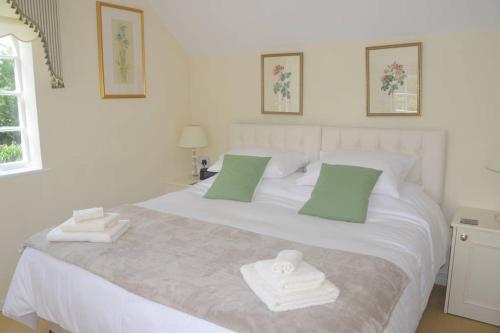 a bedroom with a white bed with towels on it at The Old Bakery, Long Street in Enford