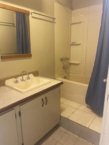 a bathroom with a sink and a bath tub at GOROKA Home Stay in Goroka
