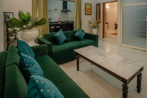 een woonkamer met groene banken en een salontafel bij The Heritage in Jodhpur