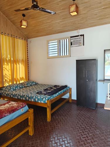 a room with two beds and a cabinet in it at His Grace BEACH AVENUE, Malpe Beach in Udupi