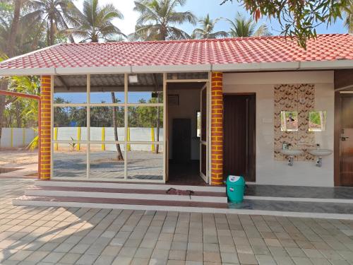a small house with a red roof at His Grace BEACH AVENUE, Malpe Beach in Udupi