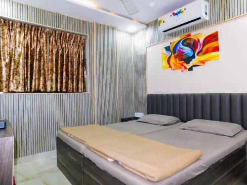 a bedroom with a bed and a painting on the wall at Hotel Nest In in Mumbai