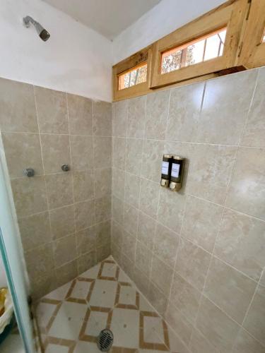 ein Bad mit einer gefliesten Dusche und einem Fenster in der Unterkunft Cabaña La Joyita By GEstores in La Venta