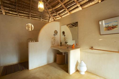 um quarto com um lavatório e um espelho na parede em Dolphin Beach Resort em Kalpitiya