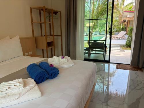 a bedroom with a bed with blue towels on it at Pinky Bungalows Resort & Villa in Ko Lanta