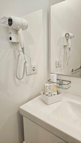 a white bathroom with a hair dryer on a sink at Interno 8 in Padova
