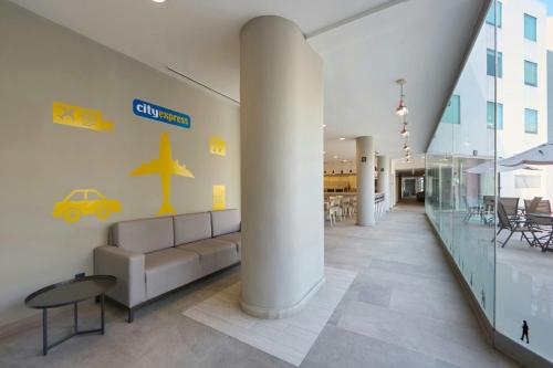 a lobby with a couch and a table in a building at City Express by Marriott Ciudad de Mexico Aeropuerto in Mexico City