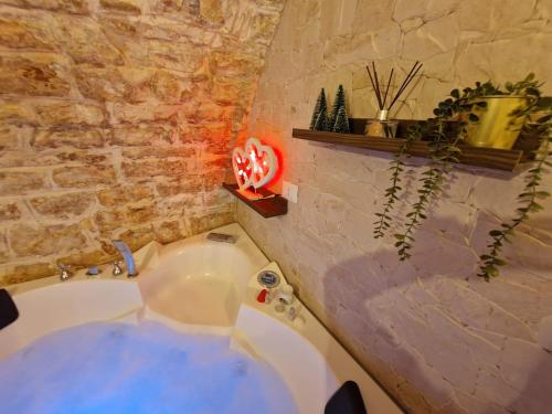 een badkamer met een bad en een stenen muur bij Soffio di Pietra in Castellana Grotte