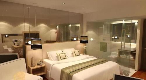 ein Schlafzimmer mit einem Bett und einer Glaswand in der Unterkunft Horison Ultima Semarang in Jomblang