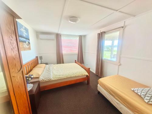 une chambre d'hôtel avec deux lits et une fenêtre dans l'établissement Christian's Minde, Jervis Bay, à Sussex Inlet