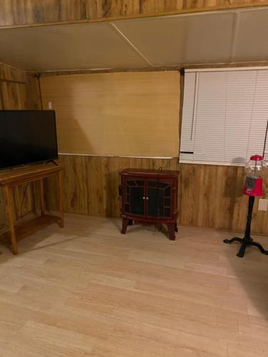 a room with a flat screen tv and a table and window at Park Model Furnished #5 in Tucson