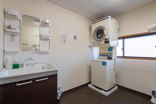 een keuken met een koelkast en een wastafel bij Guest House Ouka in Takayama