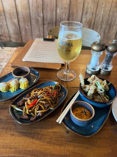 een tafel met drie borden eten en een glas wijn bij Porthcawl Trecco bay Ash91 in Newton