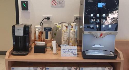 a counter with a coffee maker and a coffee machine at Ceniq Hotel in Sathani Nakhon Lampang