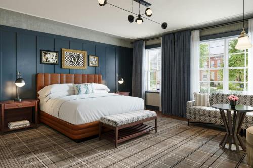 a bedroom with blue walls and a bed and a chair at The Union Hotel, Flemington, a Tribute Portfolio Hotel in Flemington