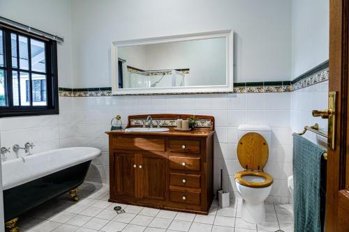 een badkamer met een wastafel, een toilet en een bad bij Three Brothers Orchard in Oakbank