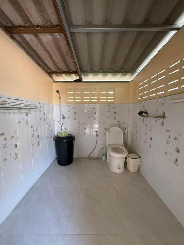 a bathroom with a toilet in a room at Baan Suan Chay Nam Homestay Amphawa in Amphawa