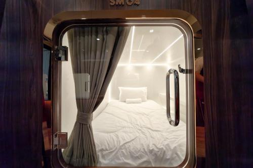 een kleine kamer met een bed erin bij The Rich Cafe & Hostel in Pattaya South