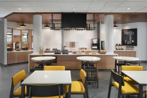达拉姆Fairfield by Marriott Inn & Suites Durham的一间带桌子和黄色椅子的餐厅和一间厨房