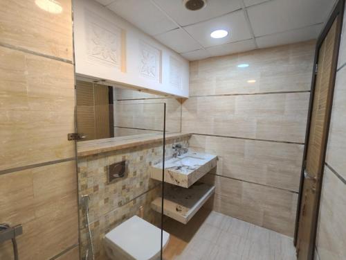 een badkamer met een glazen douche en een wastafel bij Luxury Villa Mansion Ajman in Ajman 