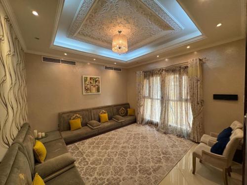een woonkamer met een bank en een raam bij Luxury Villa Mansion Ajman in Ajman 