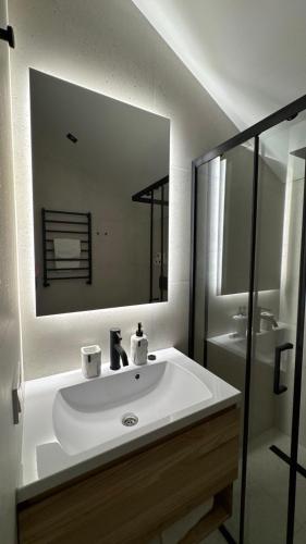 a bathroom with a white sink and a mirror at be be Chalet mini - privat pool & jacuzi in Bukovel