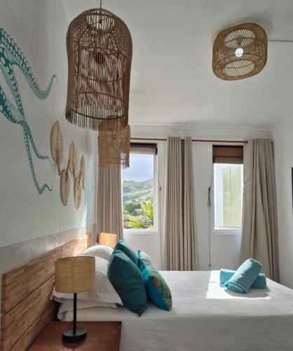 a bedroom with a bed with blue pillows and a window at Villa detente 1 in Saint Gabriel