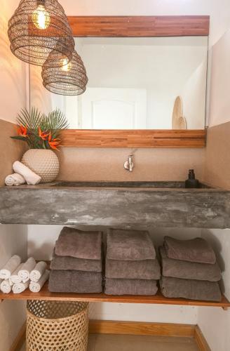 a bathroom with a shelf with towels and a mirror at Villa detente 1 in Saint Gabriel